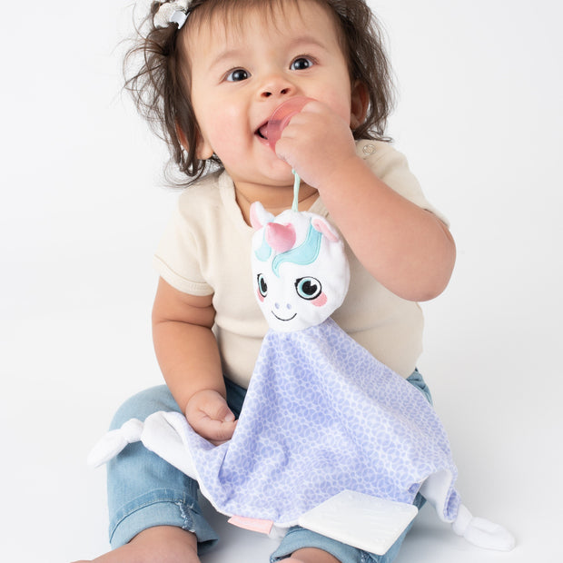 Toddler using the BooginHead Plush PaciPal Teether Blanket, Dreamer the Unicorn. Keeps track of pacifier with attaching loop. Super soft fabric from a woman owned small business. Easy to clean!