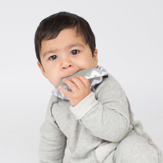 Baby girl soothing gums on BooginHead Bandana Teether in Chevron and soft cotton